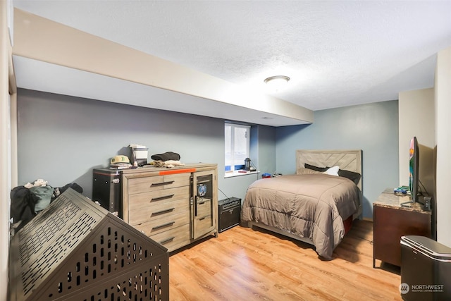 bedroom with light hardwood / wood-style floors and a textured ceiling