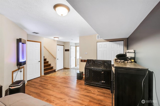 living room with a textured ceiling and wood-type flooring