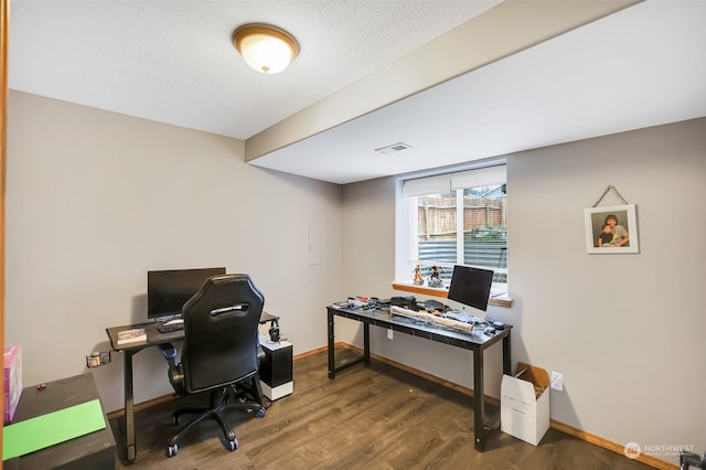 office area with dark wood-type flooring and a textured ceiling