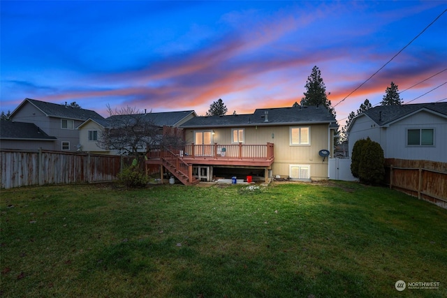 back house at dusk featuring a yard and a deck