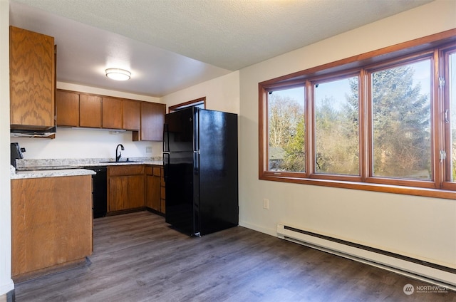 kitchen with sink, a baseboard heating unit, black appliances, a textured ceiling, and dark hardwood / wood-style flooring