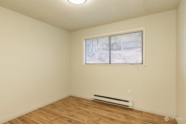 unfurnished room with light hardwood / wood-style floors, a textured ceiling, and baseboard heating