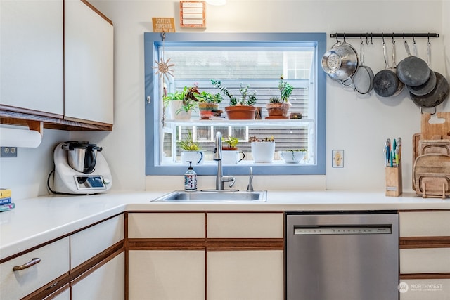 kitchen with white cabinets, stainless steel dishwasher, and sink