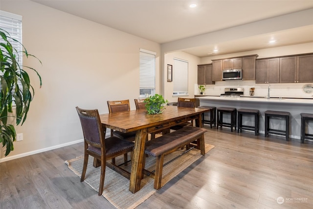 dining space featuring sink and light wood-type flooring