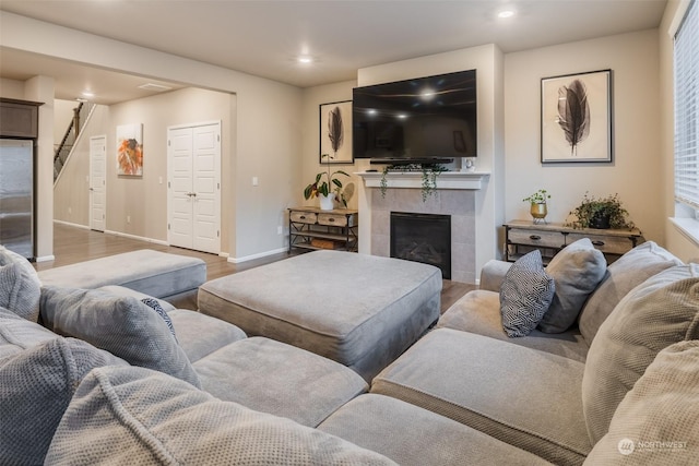 living room with light wood-type flooring and a tile fireplace