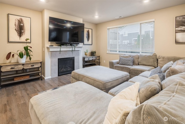 living room featuring light hardwood / wood-style flooring and a tiled fireplace