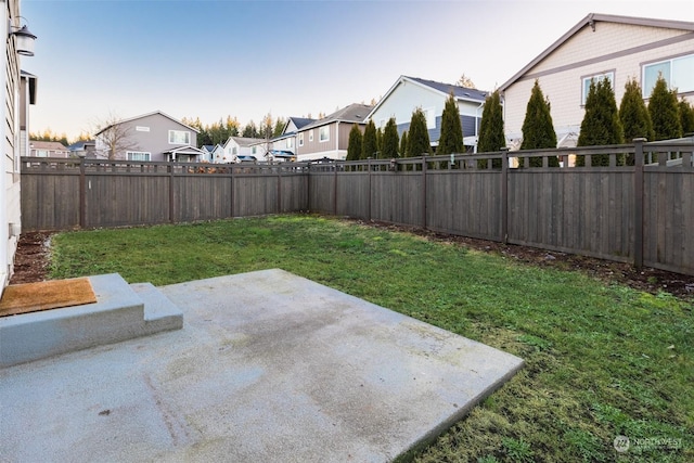 yard at dusk featuring a patio area