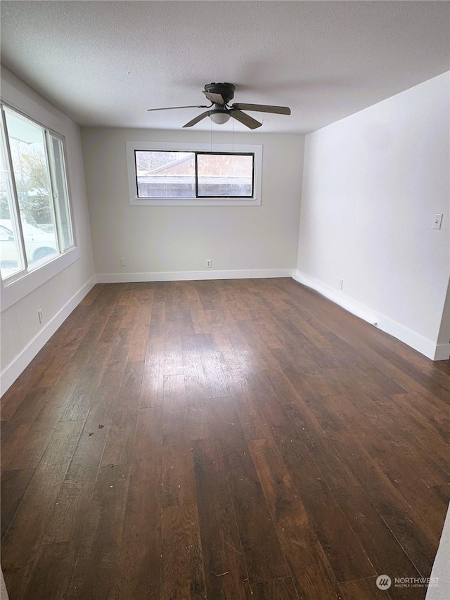 empty room with dark hardwood / wood-style flooring, ceiling fan, and a textured ceiling