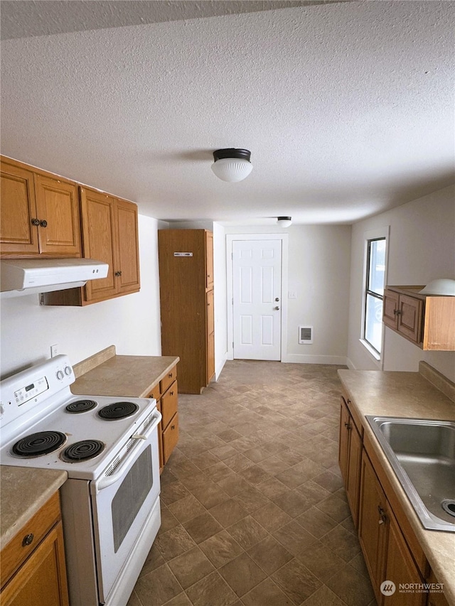 kitchen featuring electric stove, sink, and a textured ceiling