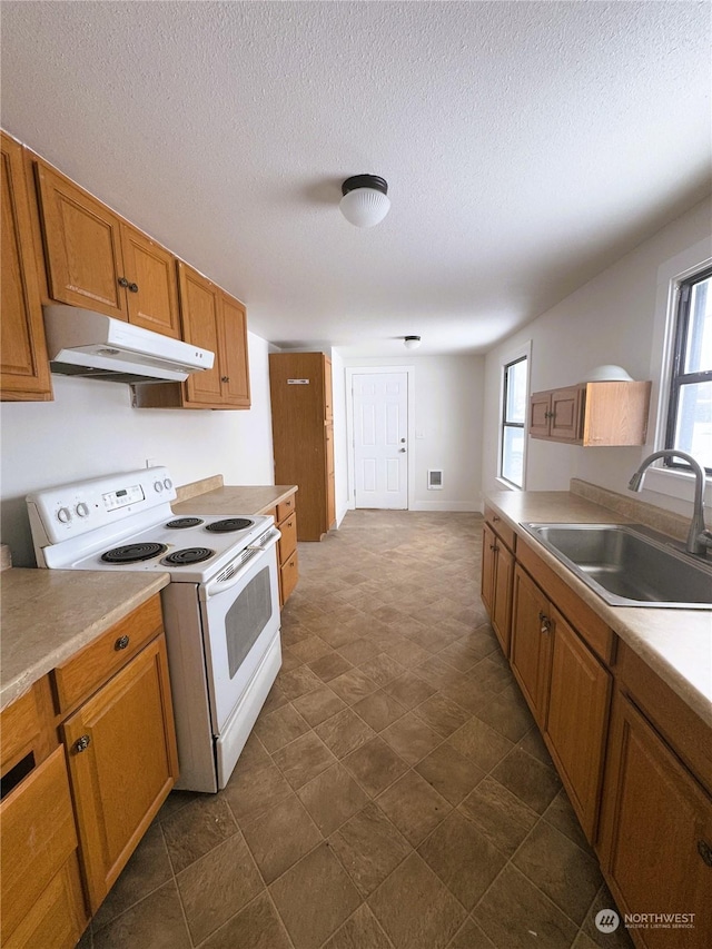 kitchen with electric stove, sink, and a textured ceiling