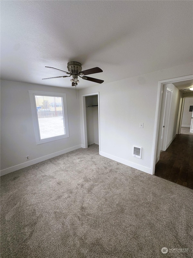 unfurnished room with ceiling fan, a textured ceiling, and carpet