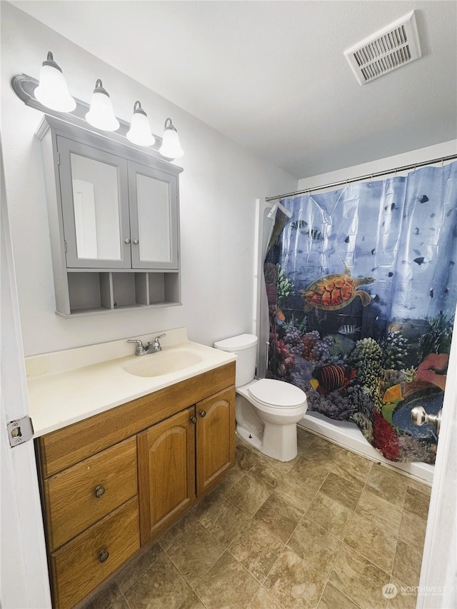 bathroom featuring vanity, curtained shower, and toilet