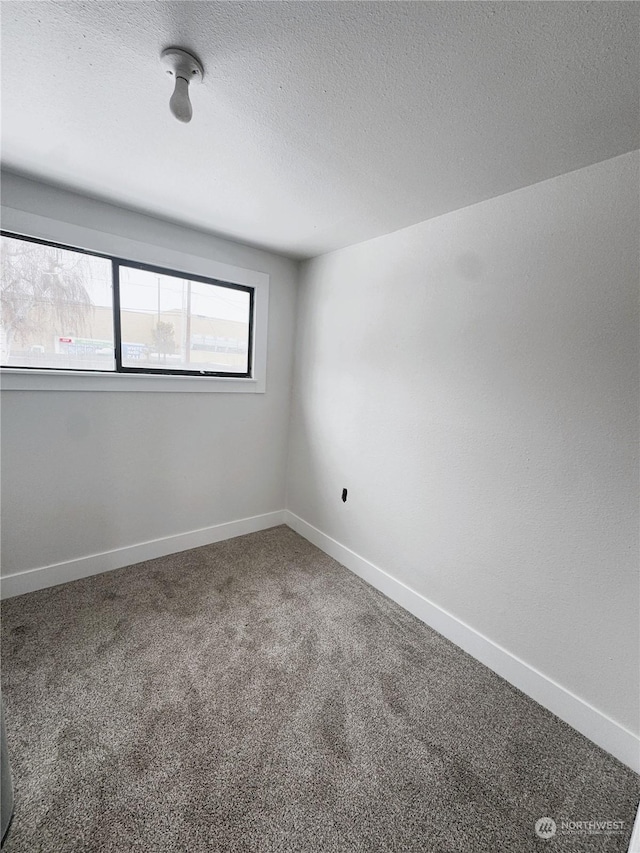 carpeted spare room featuring a textured ceiling