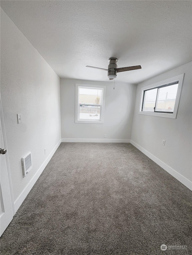 carpeted spare room with ceiling fan and a textured ceiling