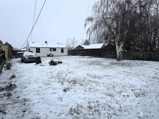 view of snow covered back of property