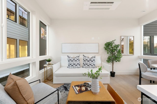 living room with plenty of natural light and light hardwood / wood-style flooring