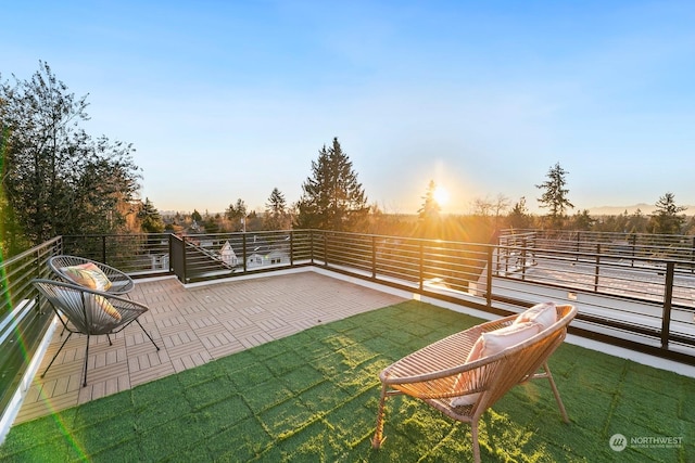 patio terrace at dusk with a balcony and a lawn