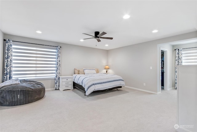 carpeted bedroom featuring a walk in closet, ceiling fan, and a closet