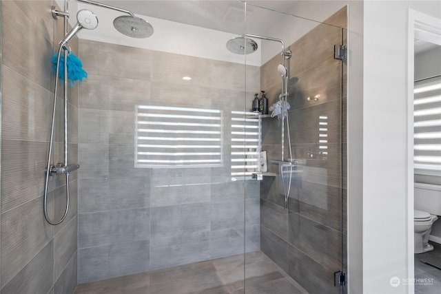 bathroom with toilet and an enclosed shower