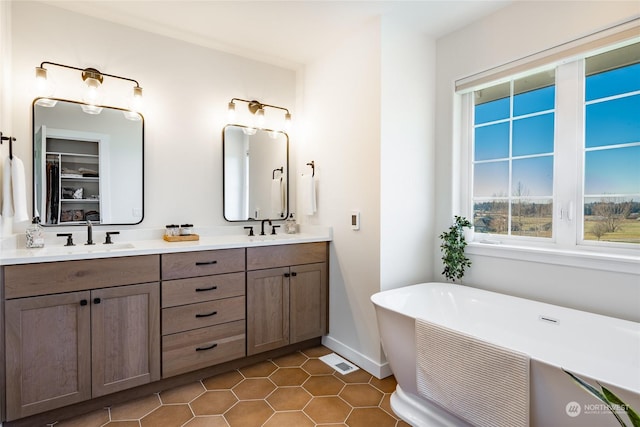 bathroom with tile patterned flooring, vanity, and a washtub