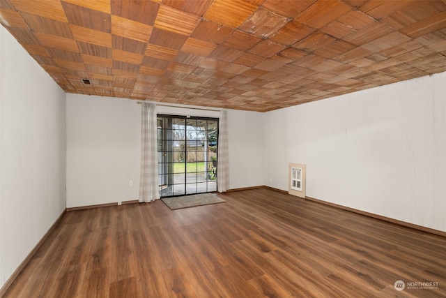 empty room with dark hardwood / wood-style floors and heating unit