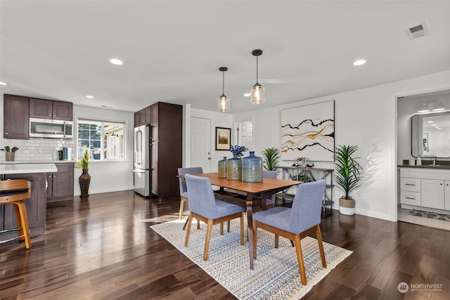 dining area with sink and dark wood-type flooring