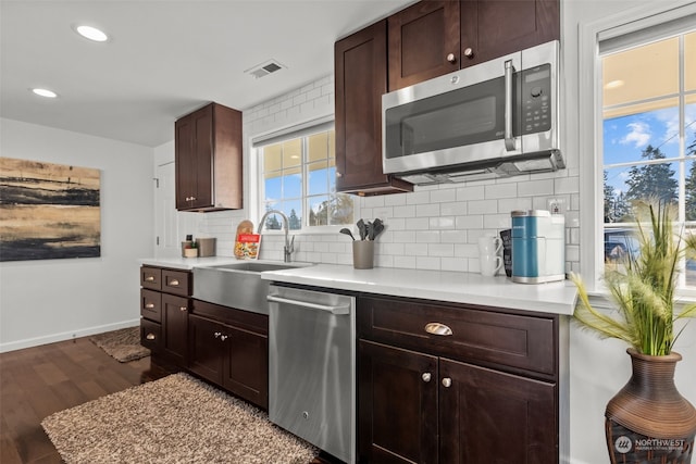 kitchen with sink, dark hardwood / wood-style floors, stainless steel appliances, and tasteful backsplash