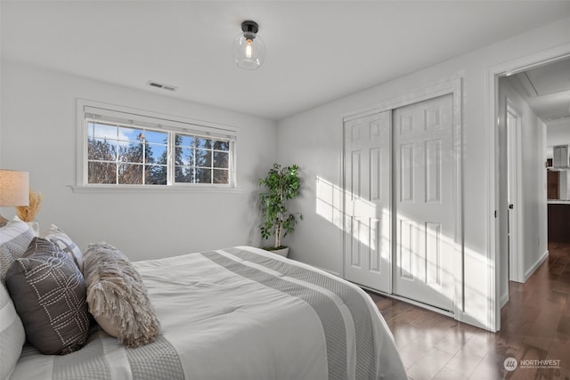 bedroom with a closet and dark hardwood / wood-style flooring