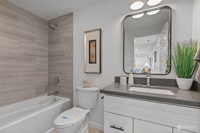 full bathroom with tiled shower / bath combo, vanity, and toilet