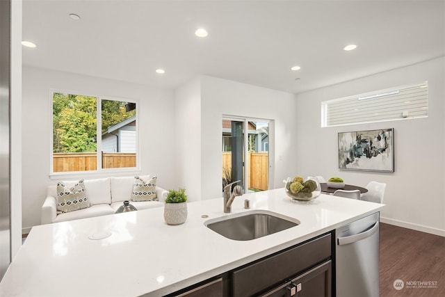 kitchen with dark brown cabinetry, dark hardwood / wood-style flooring, dishwasher, and sink