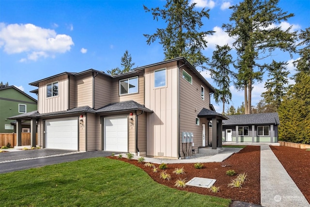 view of front of home with board and batten siding, an attached garage, driveway, and a front lawn