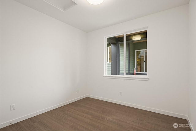 spare room featuring dark wood finished floors and baseboards