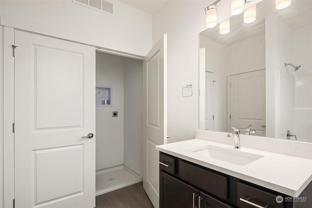 bathroom with vanity, wood-type flooring, and walk in shower