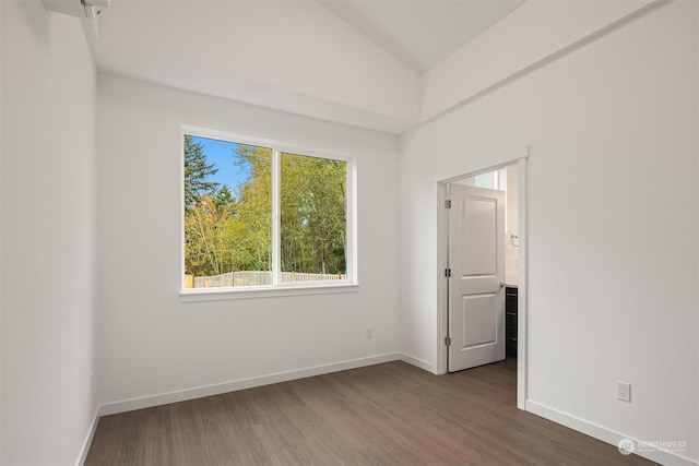 spare room with baseboards, lofted ceiling, and wood finished floors