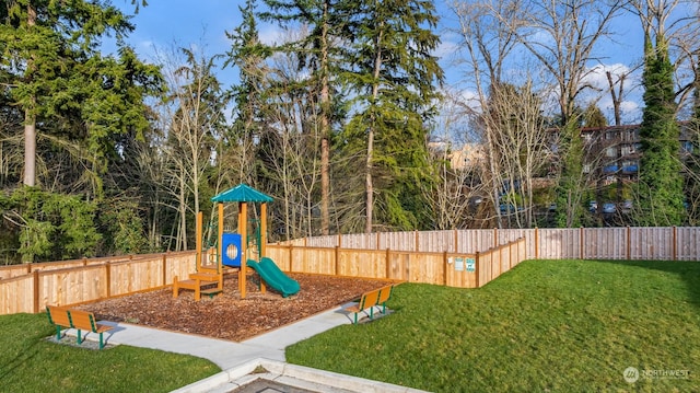 view of jungle gym with a lawn and fence