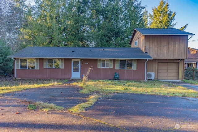 view of front of property featuring a garage and ac unit