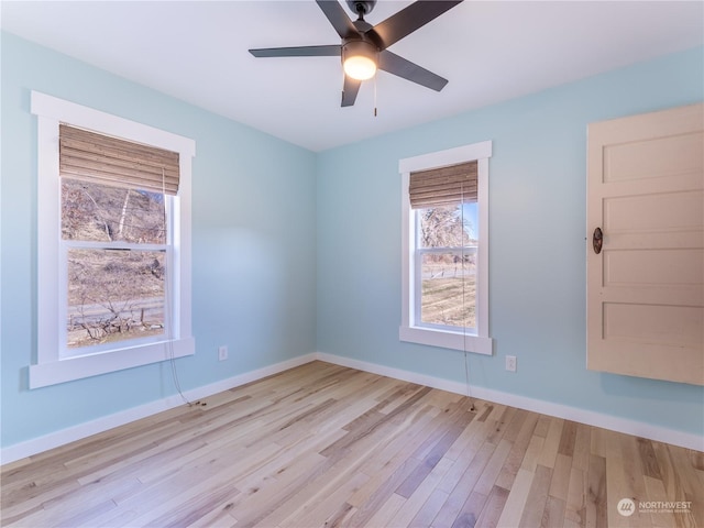 empty room with ceiling fan and light hardwood / wood-style flooring