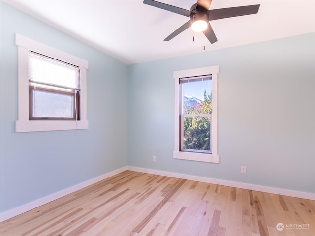 empty room with ceiling fan and light hardwood / wood-style flooring