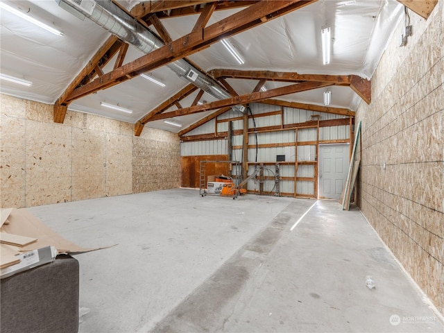 interior space featuring concrete floors and high vaulted ceiling