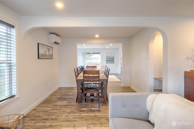 dining room featuring hardwood / wood-style flooring and a wall unit AC