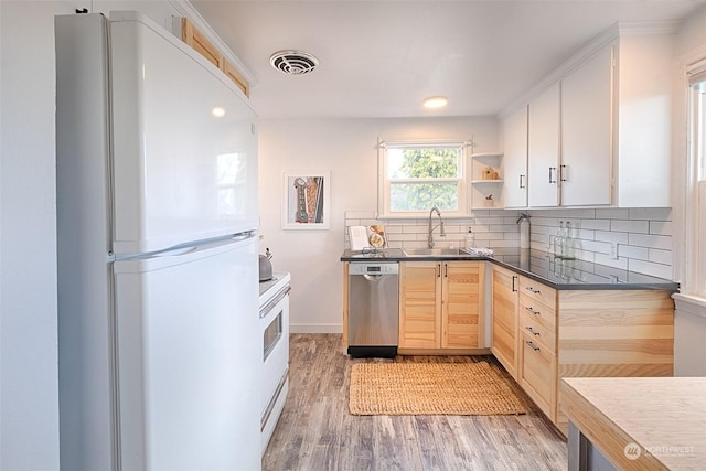 kitchen featuring light brown cabinetry, wood-type flooring, sink, decorative backsplash, and white appliances