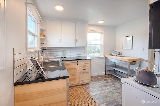 kitchen featuring wood-type flooring, sink, white cabinets, and decorative backsplash