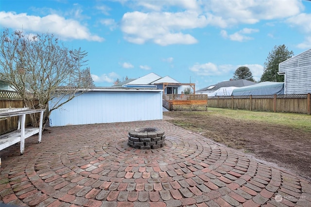 view of patio featuring an outdoor fire pit and a deck