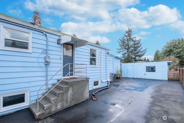 view of side of home with central AC and a patio