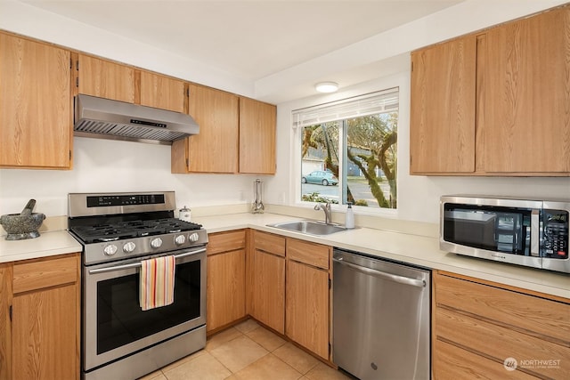 kitchen featuring stainless steel appliances, range hood, sink, and light tile patterned floors