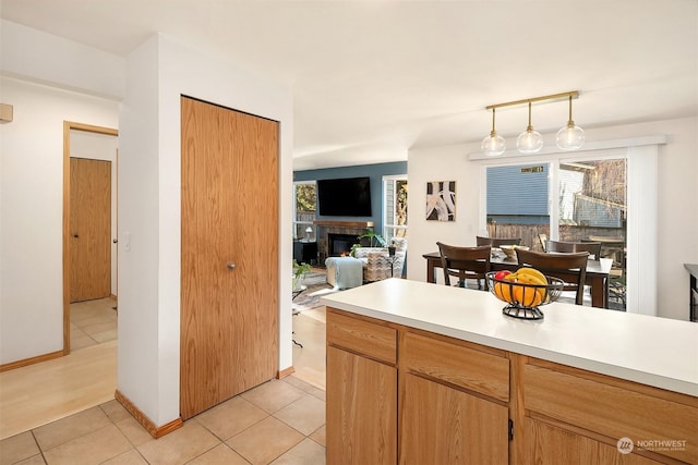 kitchen featuring light tile patterned floors, decorative light fixtures, and a fireplace