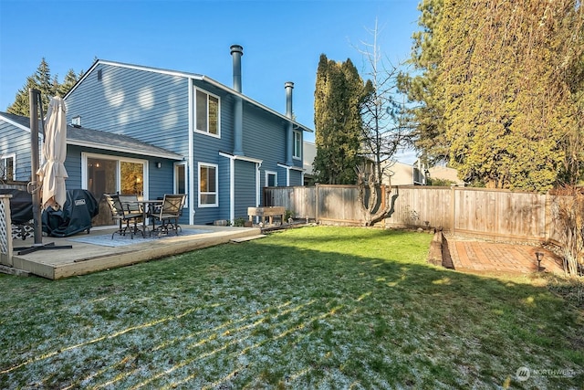 back of property featuring a deck and a lawn