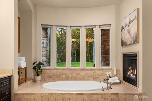 bathroom featuring vanity and tiled bath