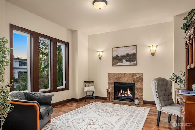 sitting room with a tile fireplace and hardwood / wood-style floors