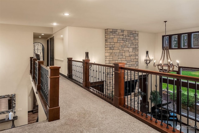 hallway with carpet flooring and a notable chandelier